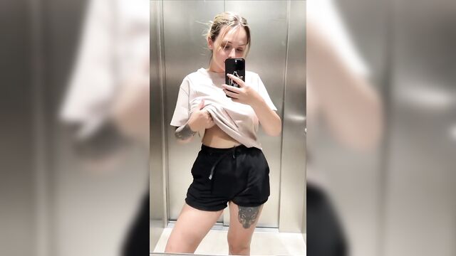 A girl is rating her big boobs from 1 to 10 in the elevator
