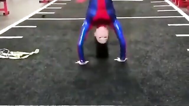 A woman with a perfect body does gymnastics on the city streets
